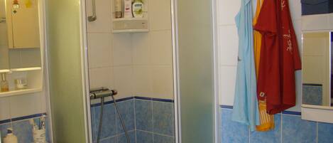 A bathroom with a shower, sink, and toilet.