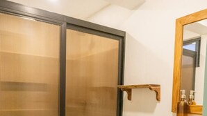 Ein Badezimmer mit Toilette, Waschbecken, Spiegel und Duschkabine.