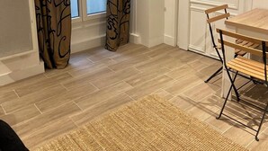 Une pièce comprenant une table à manger, des chaises, une porte et des rideaux à motifs.