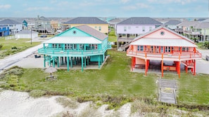 A coastal residential area with houses featuring elevated structures and a beachside view.