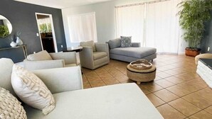 A modern living room with a sofa, armchairs, and a coffee table. - Lake house with hot tub, pool, game room & BBQ grill (Lake Elsinore)
