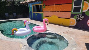 A swimming pool with inflatable unicorn and flamingo floats. - Lake house with hot tub, pool, game room & BBQ grill (Lake Elsinore)