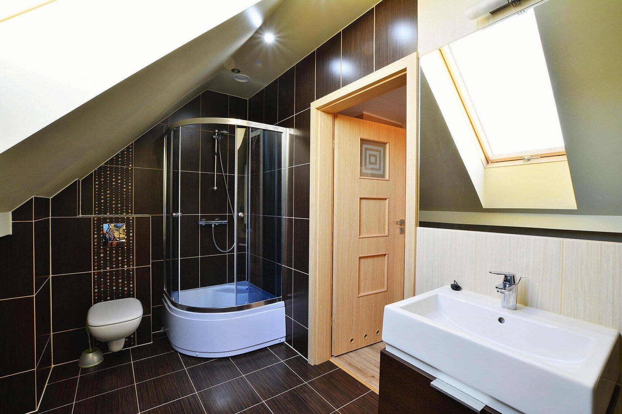 Een moderne badkamer met een douchecabine van glas, een toilet en een wastafel.