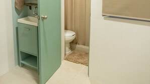 A bathroom with a sink, toilet, and shower curtain. - Shalom, The peace you need when traveling. (Campeche)