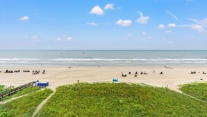 A beach with tents and a blue structure, likely a lifeguard station, on the sand. - Views & Indoor Pool - San A Bel 315 (North Myrtle Beach)