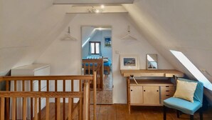 A cozy attic bedroom with a wooden bed, a desk, and a chair. - Vacation home Wolthuser Warf 3 - emden and sea - idyllic living for 4 close to the city (Emden)