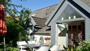 A small, modern house with a sloped roof and a large glass door leading to a covered porch. - Vacation home Wolthuser Warf 3 - emden and sea - idyllic living for 4 close to the city (Emden)