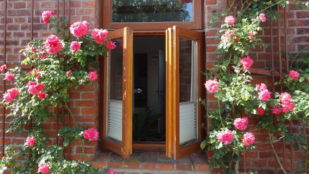 A brick building with a wooden door and a window above it. - Vacation home Wolthuser Warf 3 - emden and sea - idyllic living for 4 close to the city (Emden)