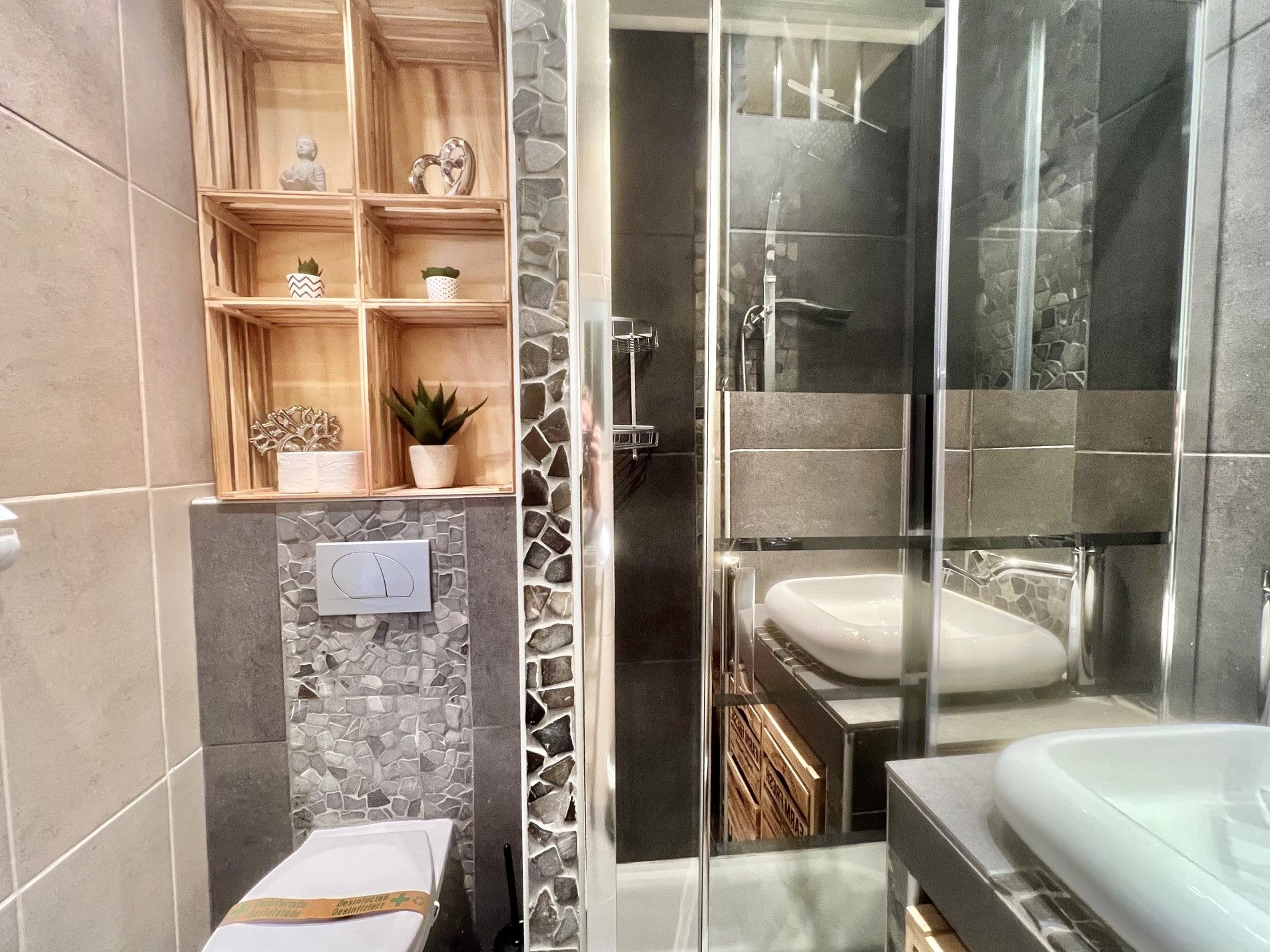 Ein modernes Badezimmer mit einer gläsernen Duschkabine, einer weißen Badewanne und einem Waschtisch.