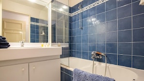 Ein Badezimmer mit Badewanne, Waschbecken und Spiegel.
