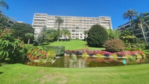 Un hôtel moderne doté d’un grand bâtiment, d’un jardin central et d’un étang.