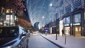 Una calle con un edificio moderno que destaca por su diseño de techo curvo.