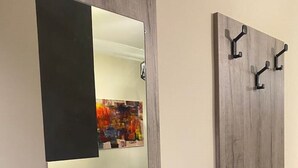A modern bathroom with a large mirror, a wooden vanity, and a towel rack.