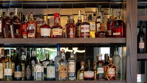 A bar area with shelves of liquor bottles and glasses.