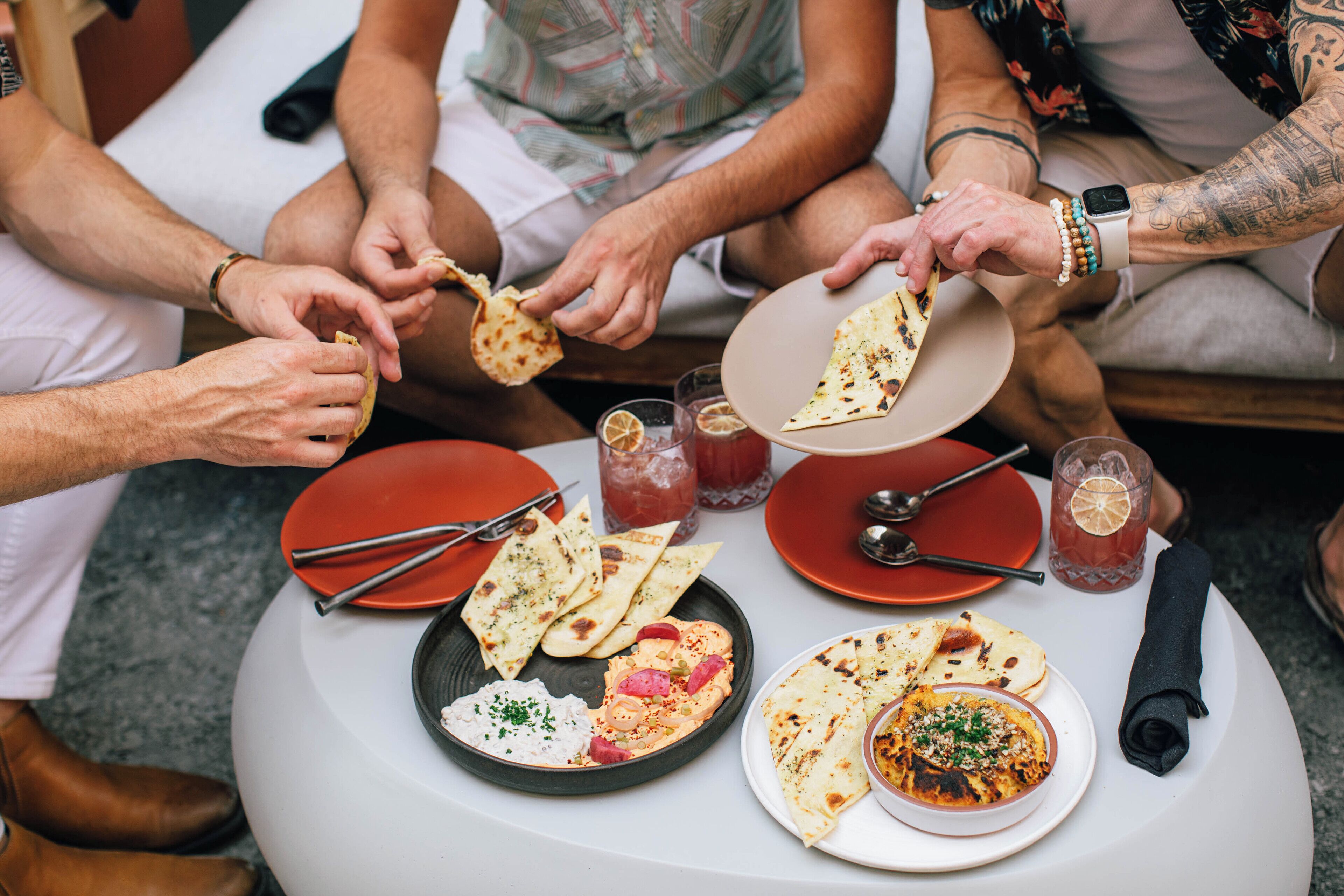 A group of people seated around a table with various dishes and drinks.