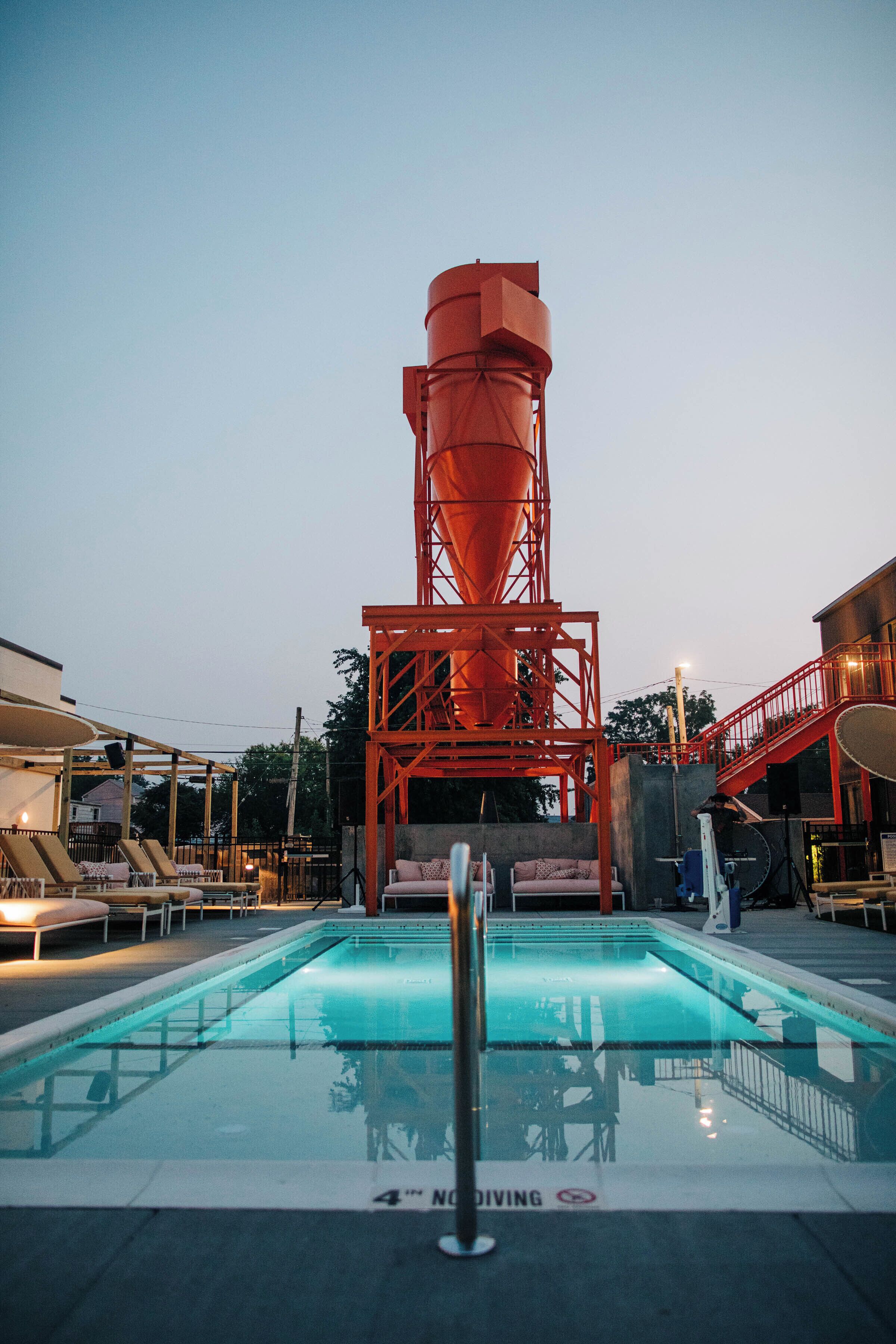 A swimming pool with a concrete structure in the background.