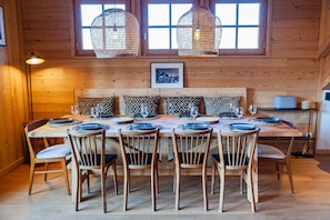 A wooden dining room with a large table set for six, surrounded by six chairs, and two hanging light fixtures above. - LA JAVA 150 m², rated 5 stars, charm and comfort AT THE FOOT OF THE SLOPES (Villard-Reculas)