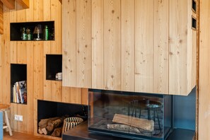 A wooden interior with built-in shelves, a fireplace, and a glass enclosure. - LA JAVA 150 m², rated 5 stars, charm and comfort AT THE FOOT OF THE SLOPES (Villard-Reculas)