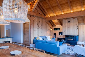 A cozy living room with a blue sofa, wooden ceiling beams, and a star decoration on the wall. - LA JAVA 150 m², rated 5 stars, charm and comfort AT THE FOOT OF THE SLOPES (Villard-Reculas)