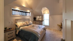 A bedroom with a bed, bedside tables, a dresser, a window, and a ceiling fan. - Gorgeous Midtown 3 Bedroom Home (Omaha)