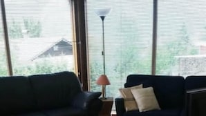 A living room with a dark blue sofa, a white coffee table, and a TV on a stand.
