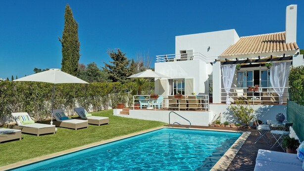 Una piscina con sillones de descanso y una zona de terraza.