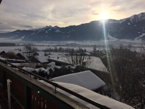 A snowy mountain landscape with a view of a town and houses covered in snow.