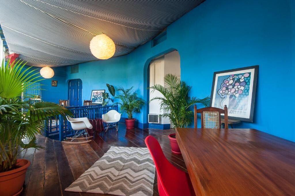 A room with a blue wall, wooden furniture, and potted plants.