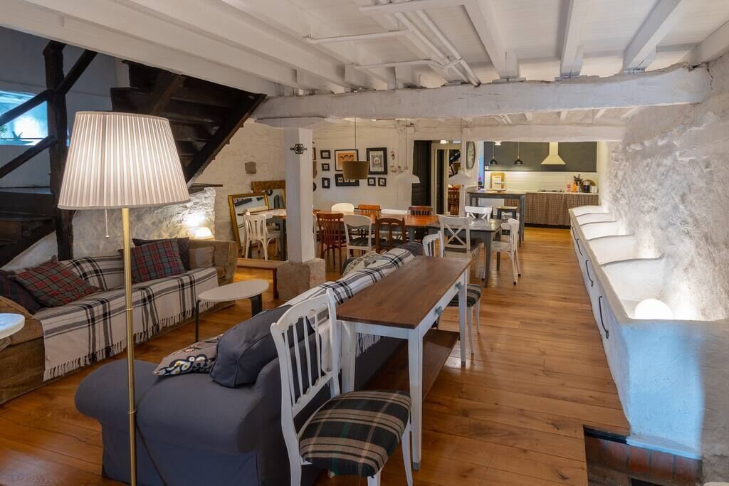 Una sala de estar acogedora con un sofá, una mesa de comedor de madera y una lámpara.