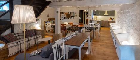Una sala de estar acogedora con un sofá, una mesa de comedor de madera y una lámpara.