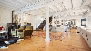 Un loft espacioso con techos altos a la vista, una escalera y una combinación de zonas de estar.