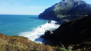 Un paisaje costero con una montaña destacada y una playa.
