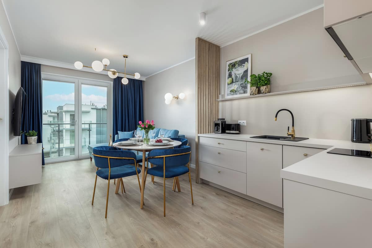A modern kitchen with a dining area, a large window, and a view of the city.