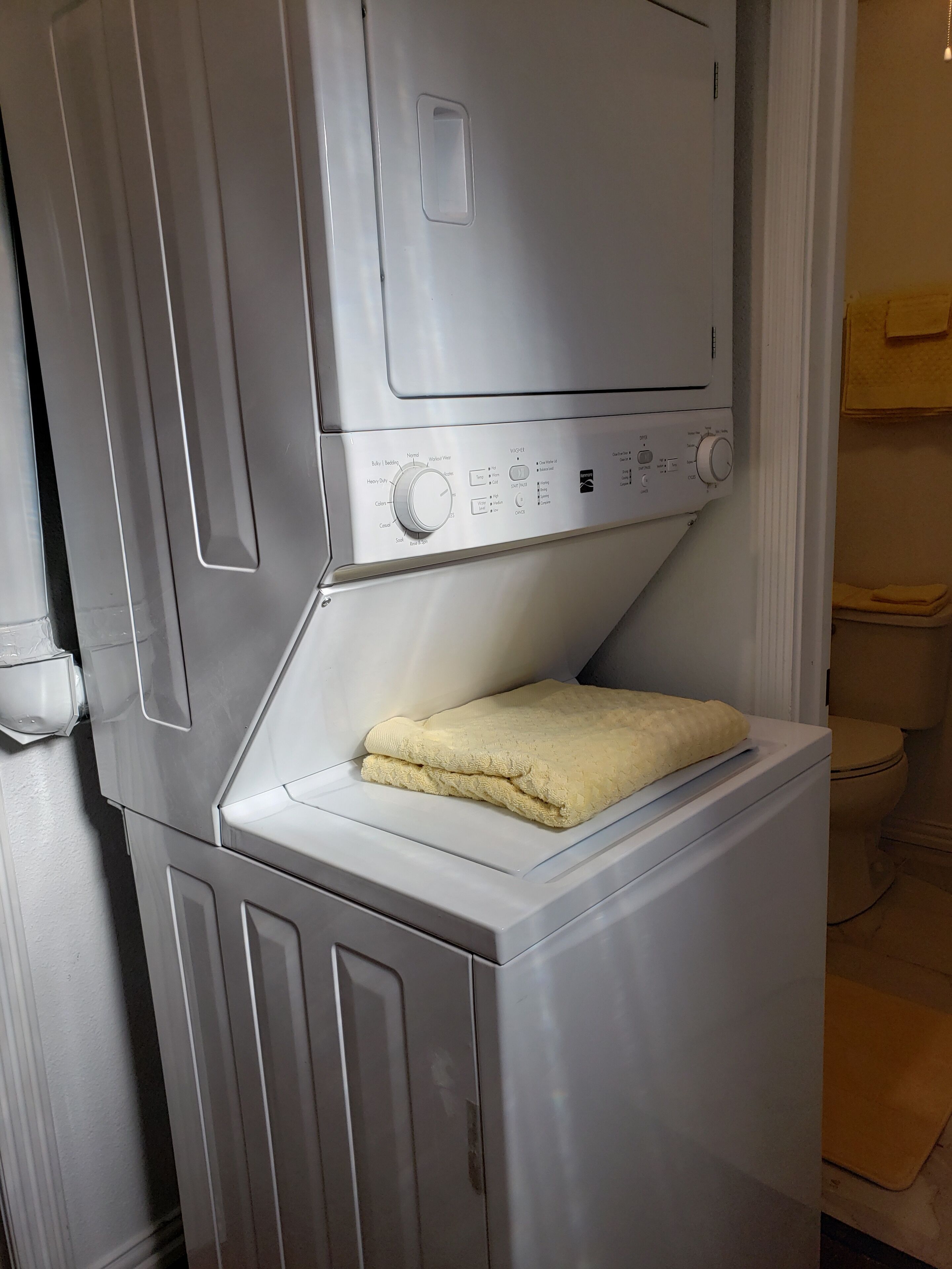 A compact, modern laundry room with a front-loading washing machine and dryer.