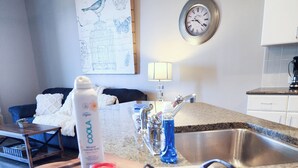 Une cuisine dotée d’un plan de travail en granit, d’un évier et d’un coin repas avec une table et des chaises.