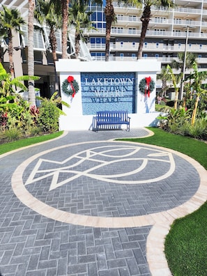 A hotel entrance with a sign reading "LAKETOWN WHARF", a bench, and a circular pavement design. - Privacy on the 4th Floor, No Elevators needed, Updated With Fountain Show View! (Panama City Beach)