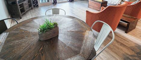 Un salon moderne avec une table ronde en verre, un canapé et un téléviseur.