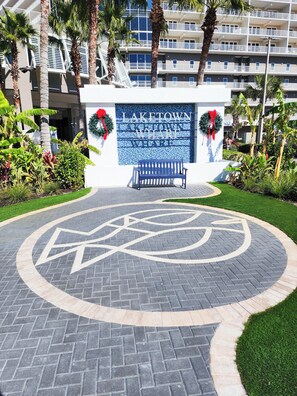 A hotel entrance with a sign reading "LAKETOWN WHARF", a bench, and a circular pavement design.
