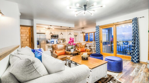 A modern living room with a sofa, ottomans, and a coffee table.