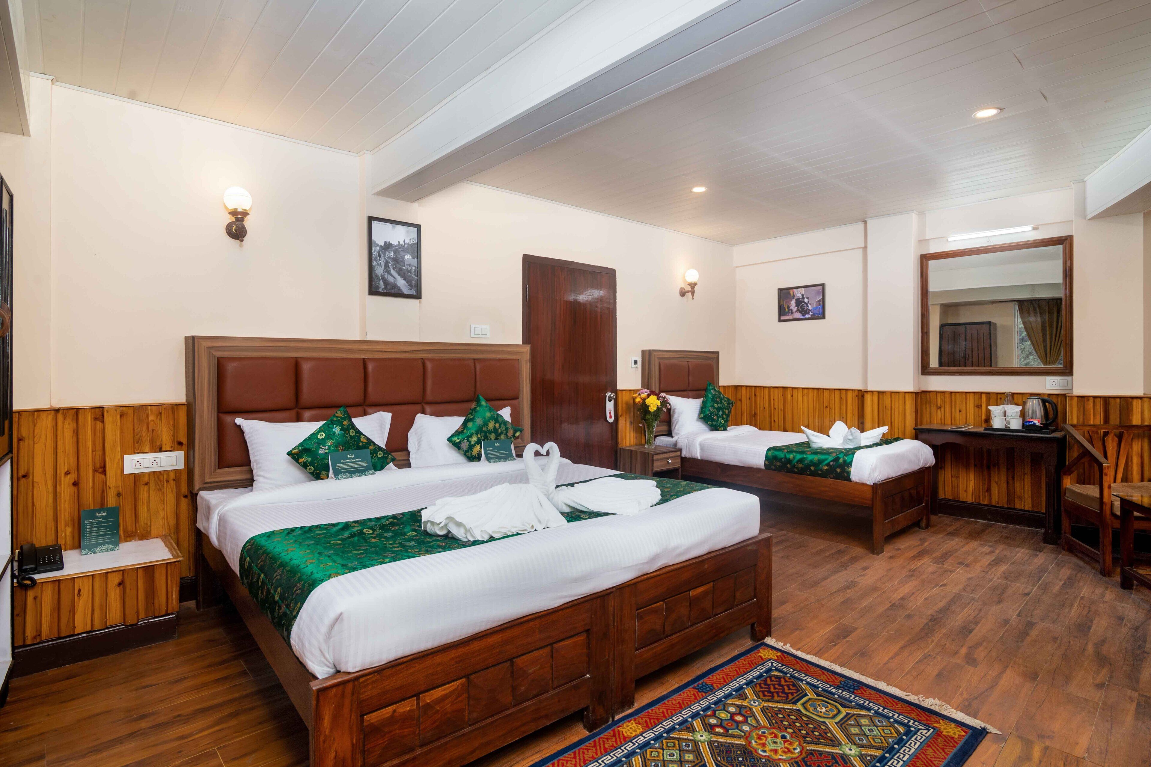 A hotel room with two beds, wooden headboards, and a large mirror.