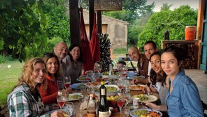 A group of people dining outdoors at a wooden table with various dishes and drinks. - Belvedere Farmhouse: 2 Bedrooms, 2 Bathrooms, AC | Bolgheri & Sea at 10 minutes (Castagneto Carducci)