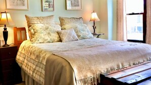 Un dormitorio con una cama, dos mesitas de noche y decoración en la pared.