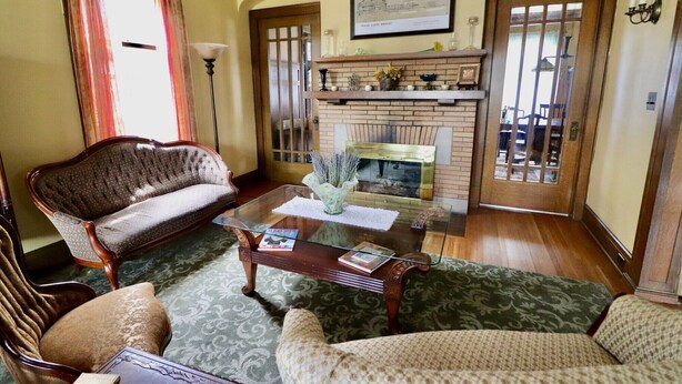 Una sala de estar con chimenea, un sofá, una mesa de centro y una alfombra estampada.
