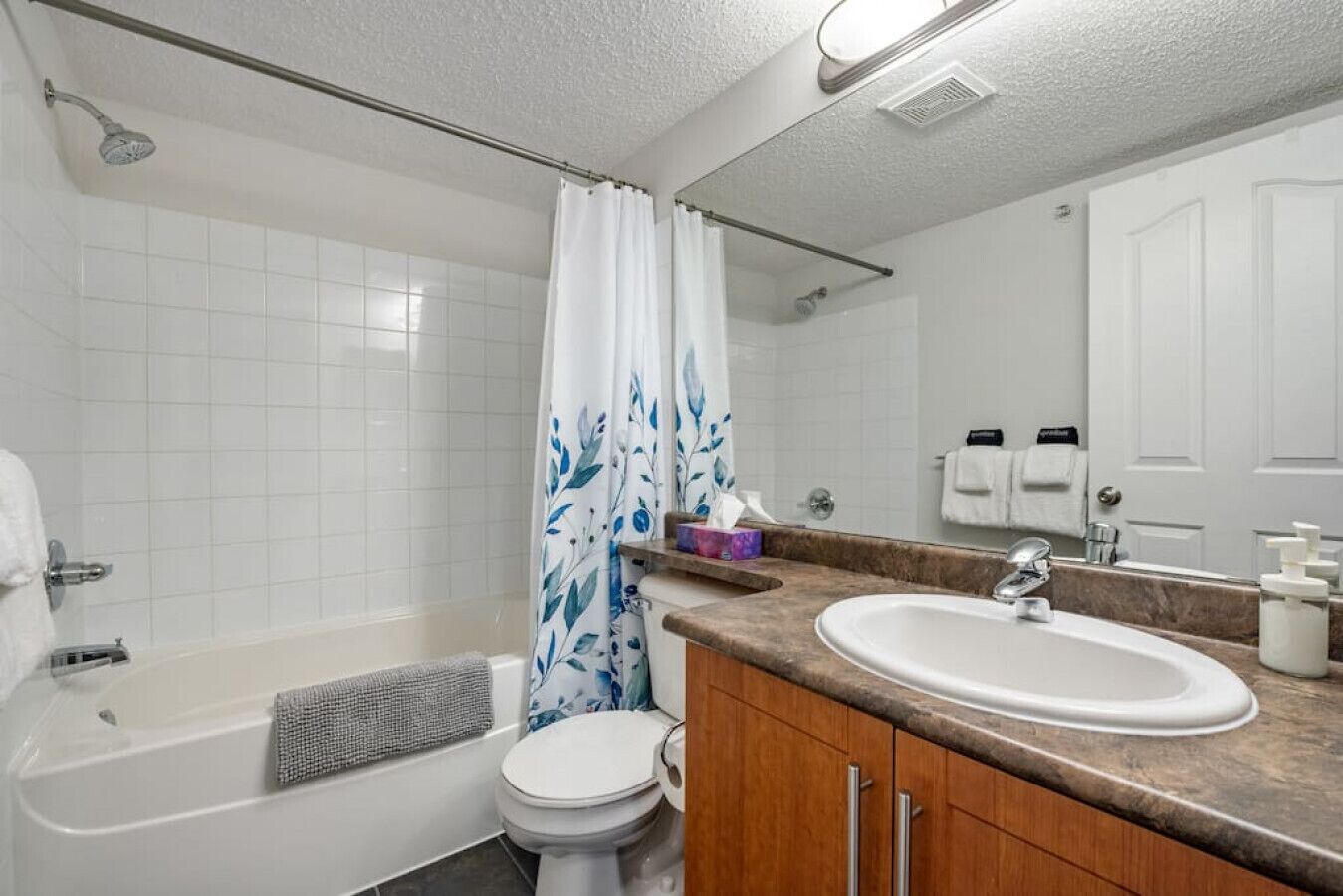A bathroom with a bathtub, toilet, and sink.