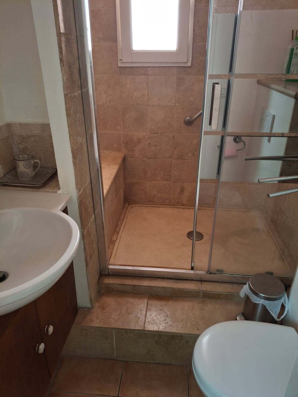 A bathroom with a shower, toilet, and sink.