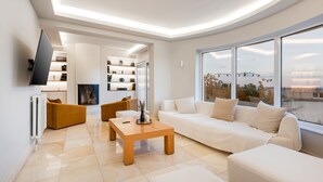 Un salon moderne avec un canapé, une table basse et un téléviseur fixé au mur.