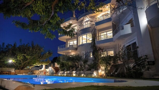 Un immeuble à plusieurs étages doté de balcons, d’une piscine et d’un espace extérieur aménagé pour s  ’asseoir.