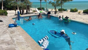 A swimming pool with clear blue water, surrounded by palm trees and a sandy beach. - New Private Pool, Private Beach and Flat, Private House, what else do you need? (Whymms)