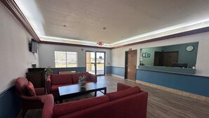 A lobby with a red sofa, a coffee table, and a reception desk. - Budget Inn, Hwy 41 (Barnesville)
