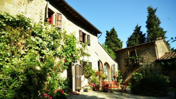 A stone building with arched windows and a staircase leading to a second level. - Cozy little retreat in wonderful location, with pool (località Fornello, Pontassieve)